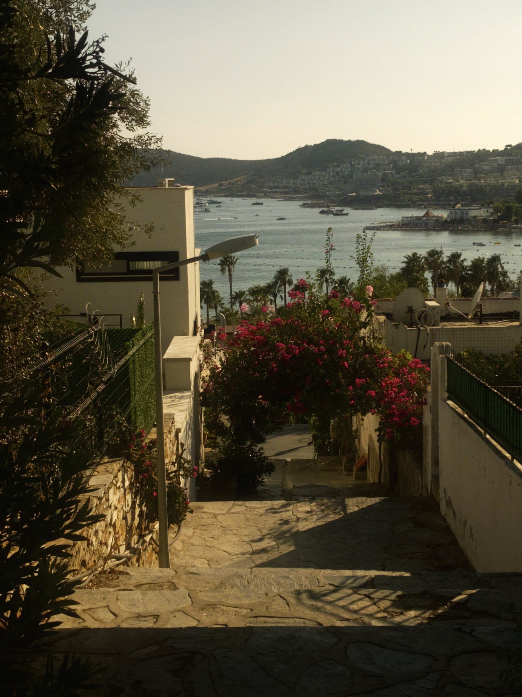 A stepped Bodrum lane with bougainvillea opening onto a view of the bay