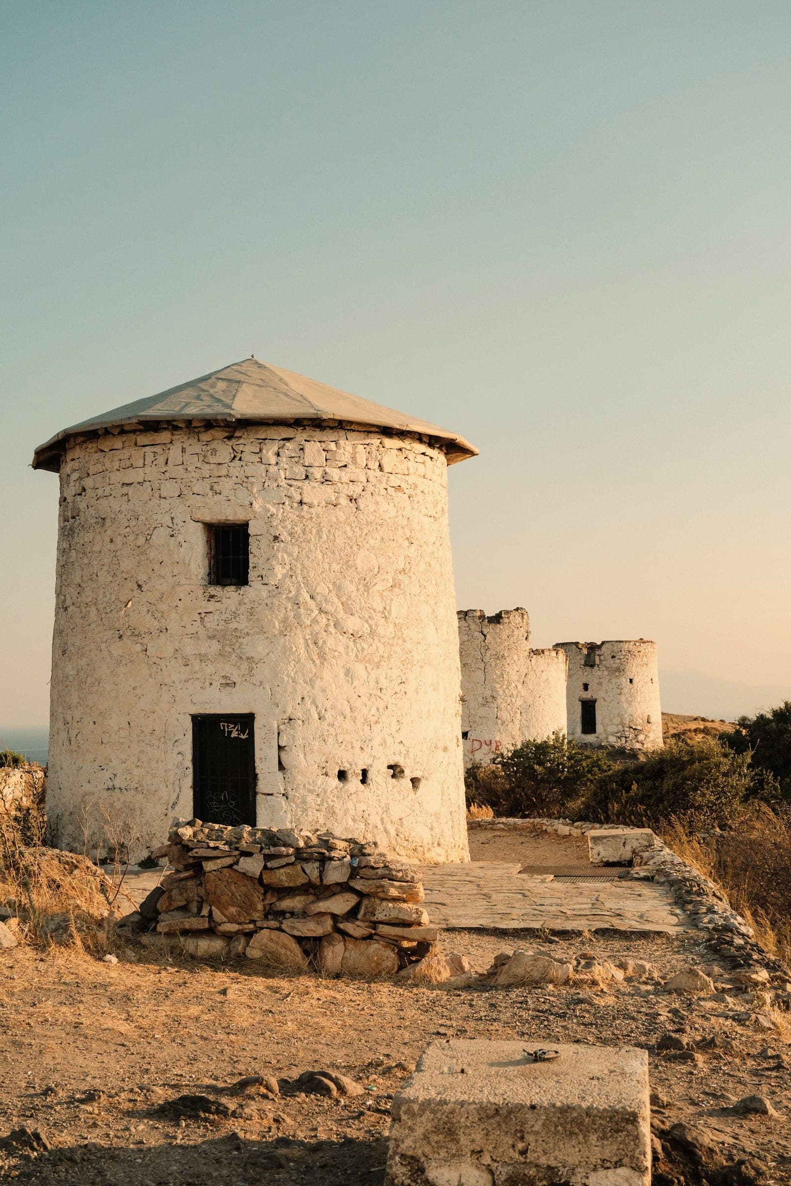 White stone windmills in Bodrum in warm sunset light