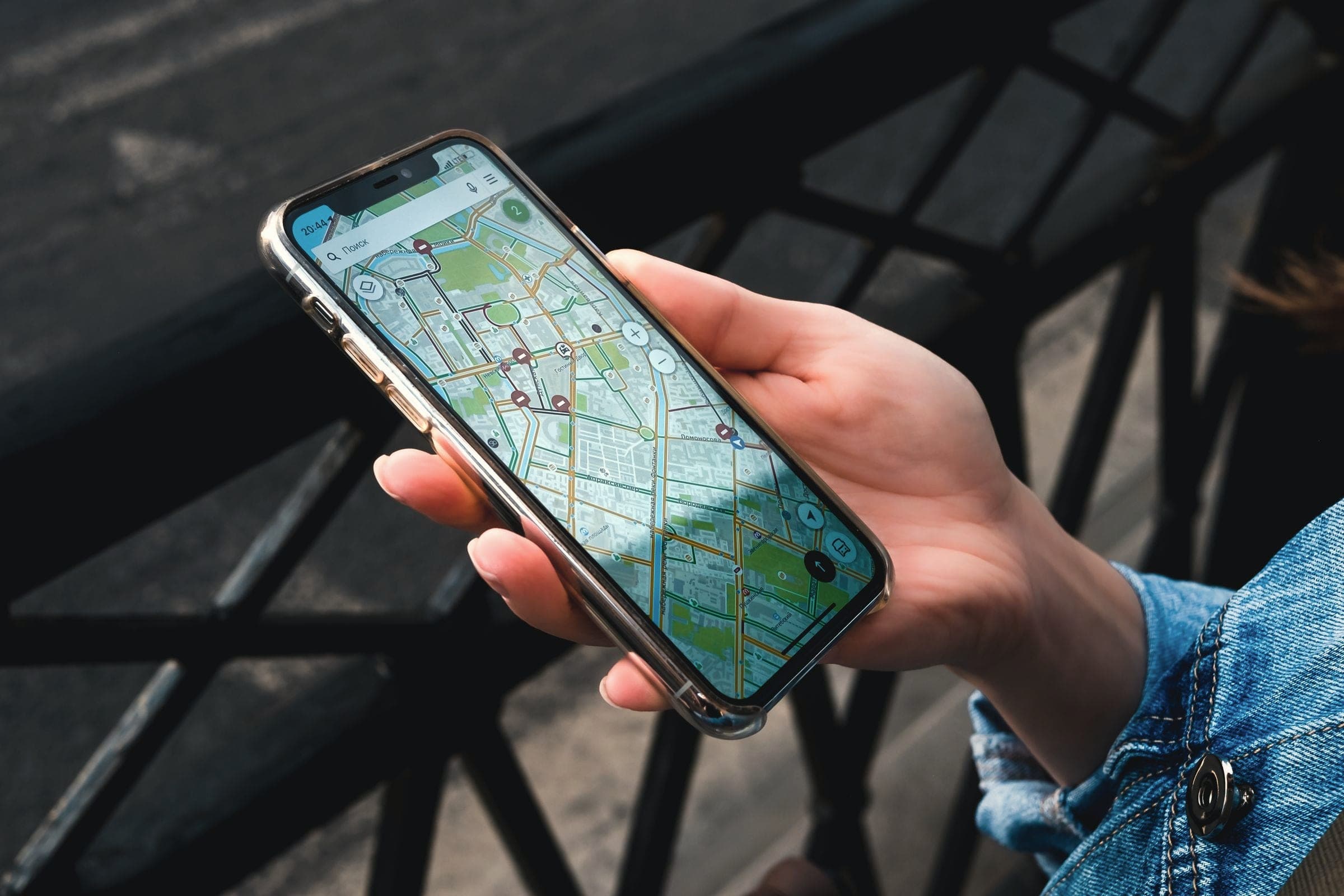 A hand holding a phone that shows a map app
