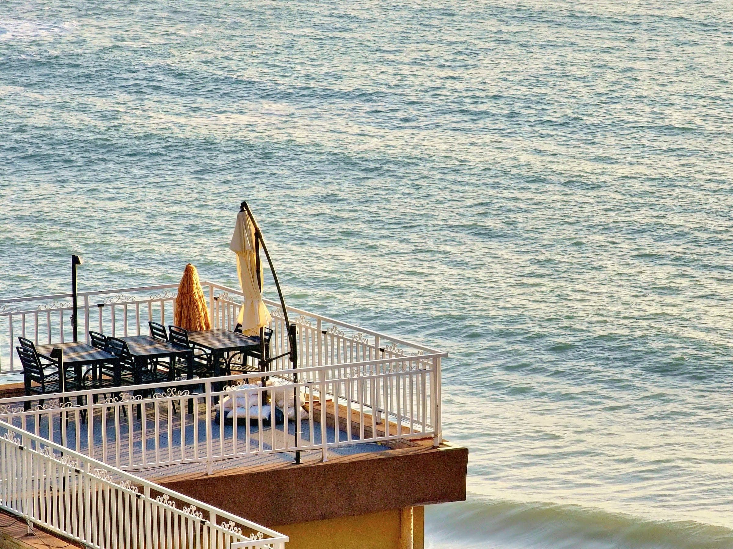 A seaside terrace with empty tables before the season, seen from above