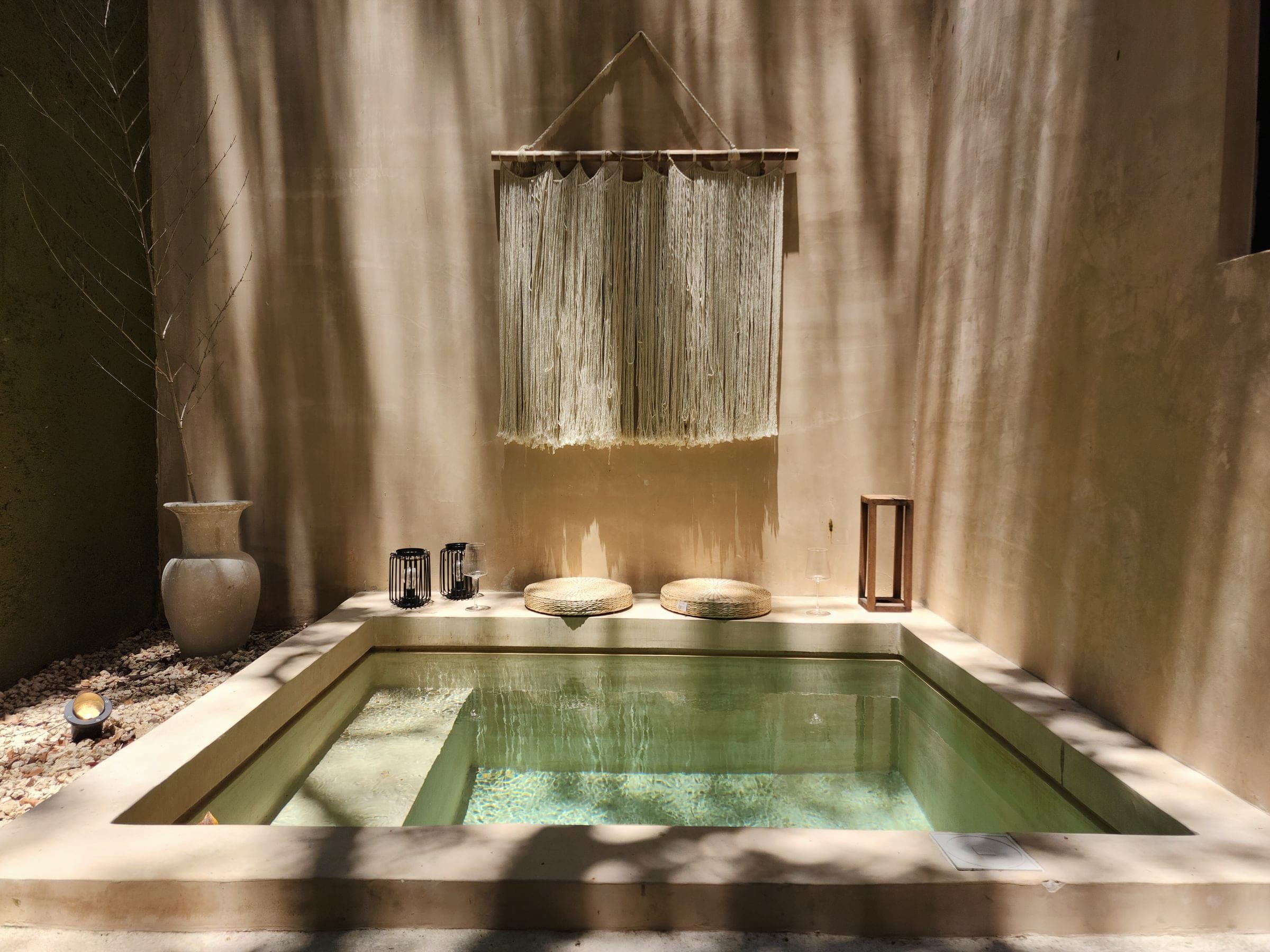 A minimal spa space with a stone bath lit by natural light