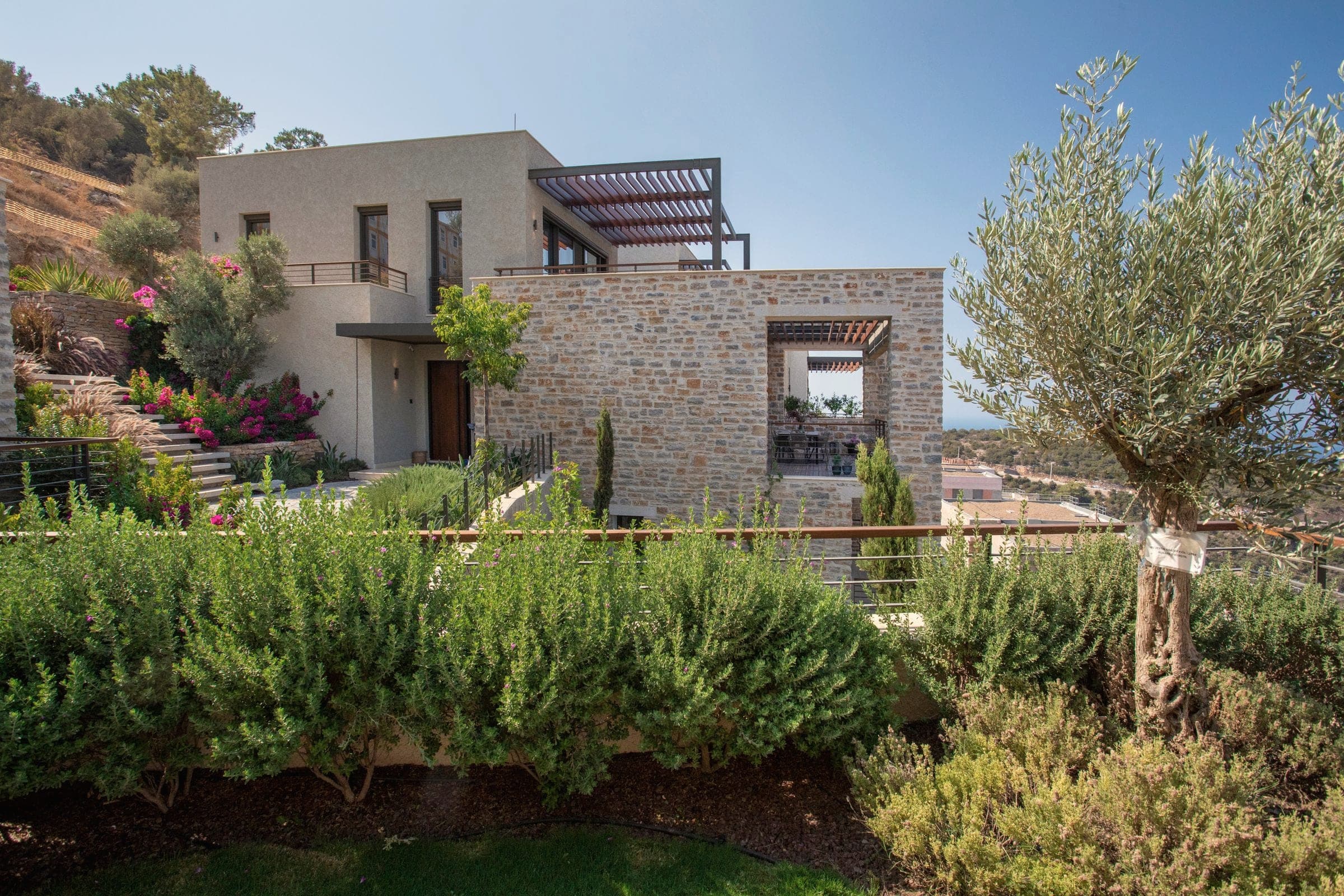 A modern stone-faced villa with an olive tree and garden in Bodrum